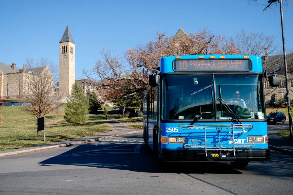 A bright blue TCAT bus on Route 10 at Cornell.